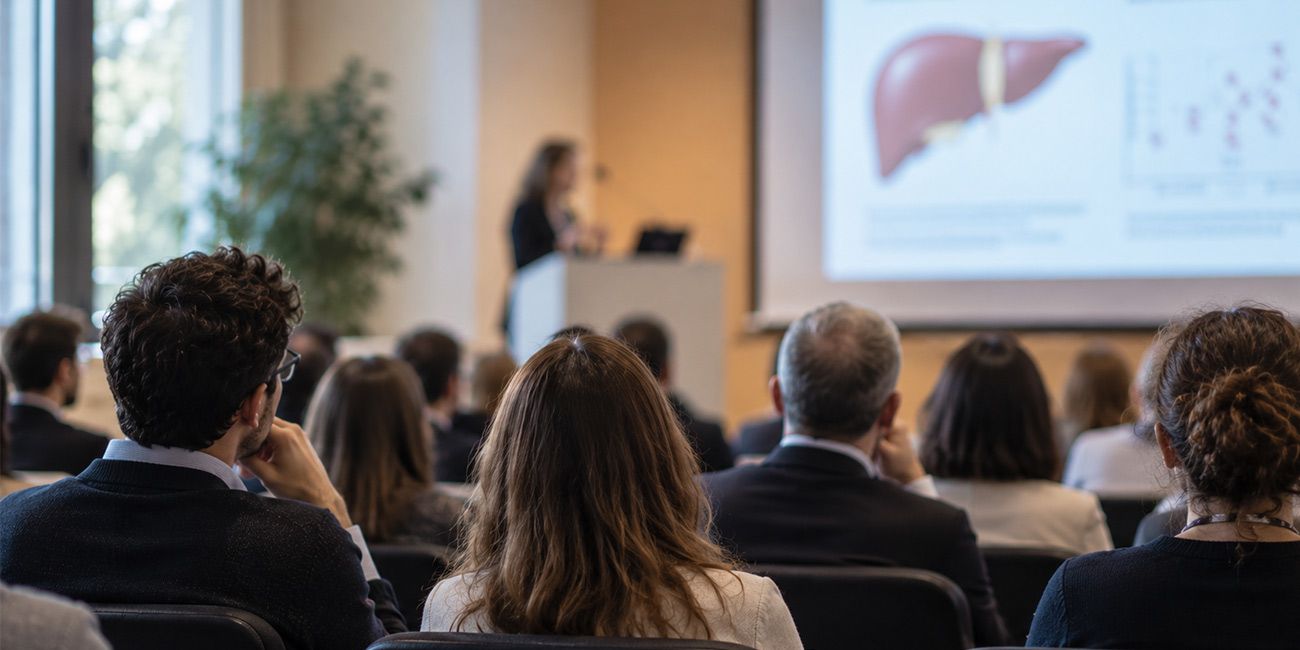 Conferenza scientifica sui disturbi alcol-correlati con professionista che presenta una slide dedicata al fegato.
